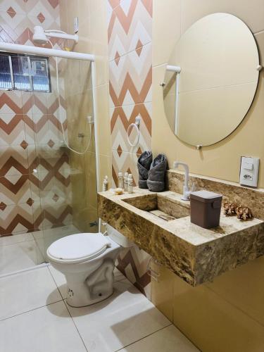 a bathroom with a toilet and a sink and a mirror at Aconchego da Serra ibiapaba in Ipu