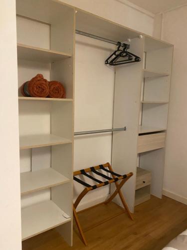 a closet with white shelves and a chair at Chez Lisoune Gite de charme sur terrasse et cour in Laragne