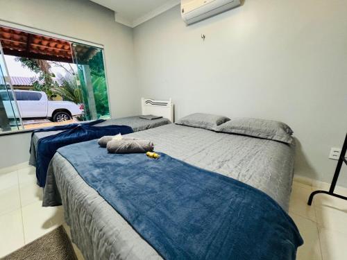 a bedroom with two beds with blue sheets and a window at Aconchego da Serra ibiapaba in Ipu