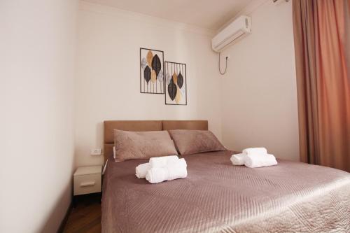 a bedroom with a bed with two towels on it at Villa Reve de Tirana in Tirana