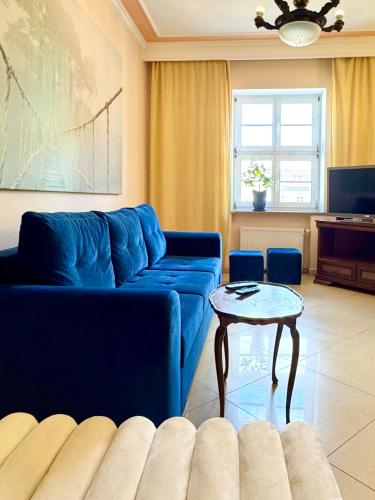 a living room with a blue couch and a table at Wroclaw Inn Apartments in Wrocław