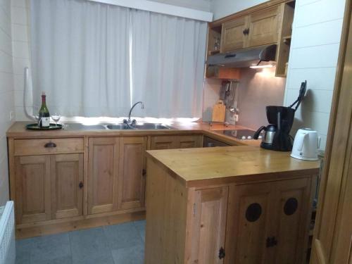a kitchen with wooden cabinets and a sink at Le silence de Frahan in Bouillon