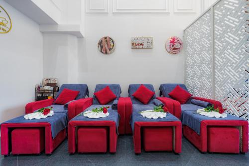 a living room with red furniture and red pillows at Salute Saigon Hotel and Spa in Ho Chi Minh City