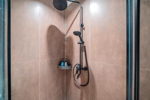 a shower with a shower head in a bathroom at Guangzhou Canton Fair Jufeng Administrative Hotel Poly World Trade Center Branch in Guangzhou