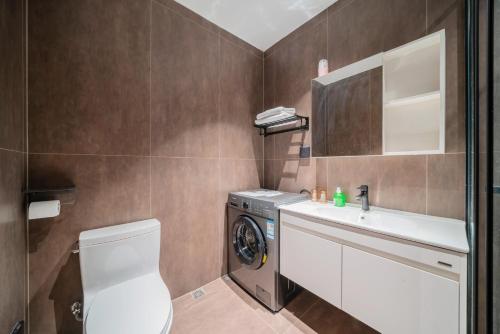 a bathroom with a washing machine and a sink at Guangzhou Canton Fair Jufeng Administrative Hotel Poly World Trade Center Branch in Guangzhou