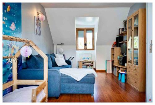 un salon avec un canapé bleu et une chambre dans l'établissement Charmante maison entre Paris et Disney, à Courtry
