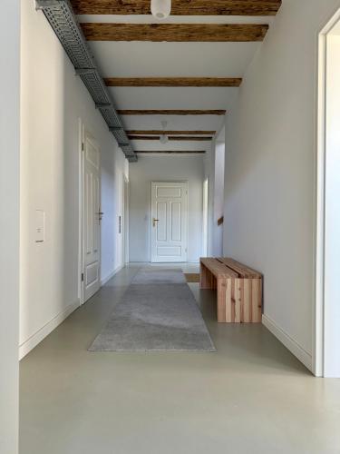 an empty hallway with a door and a wooden bench at Gesamtes Historisches Kapitänshaus in Fehmarn