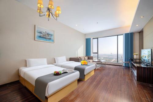 a hotel room with two beds and a couch at Guangzhou Canton Fair Jufeng Administrative Hotel Poly World Trade Center Branch in Guangzhou