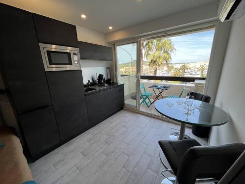 une cuisine et une salle à manger avec une table et une fenêtre dans l'établissement Studio 2 couchage Cap d'Agde Naturisme CN040-742, au Cap d'Agde