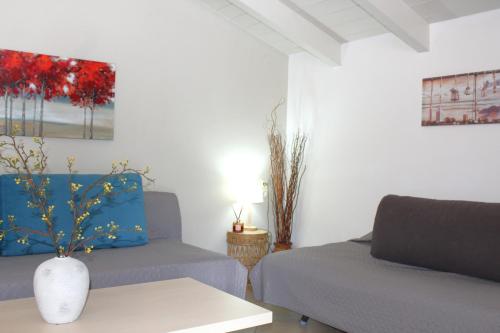 a living room with two beds and a vase on a table at Fissas Rooms in Sivota