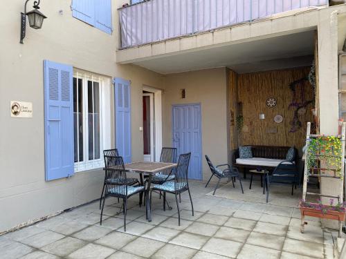 a patio with chairs and a table and a bench at Chez Lisoune Gite de charme sur terrasse et cour in Laragne