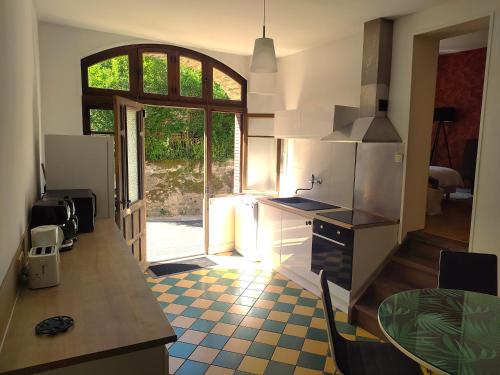 une cuisine avec un comptoir, une table et une fenêtre dans l'établissement Grand appartement 3 étoiles avec terrasse dans maison vigneronne 18éme siècle, à Saint-Lothain