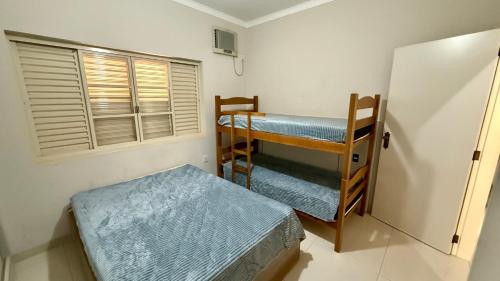 Cette chambre comprend deux lits superposés et un réfrigérateur. dans l'établissement Casa Região Central, à Olímpia