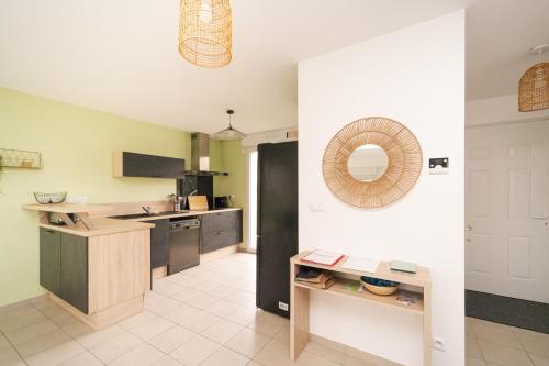 une cuisine avec des murs verts, un comptoir et une table dans l'établissement Les Rives de Chenonceaux, à Civray-de-Touraine