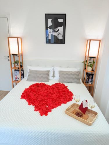 a bed with a heart made out of red roses at La casa di Sebastian in Como