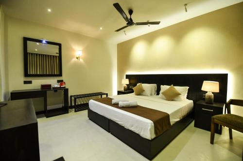 a bedroom with a large bed and a desk at Hiriketiya Beach Resort in Hiriketiya