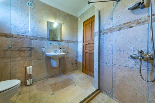 a bathroom with a shower and a sink and a toilet at Villa Gelincik in Kas