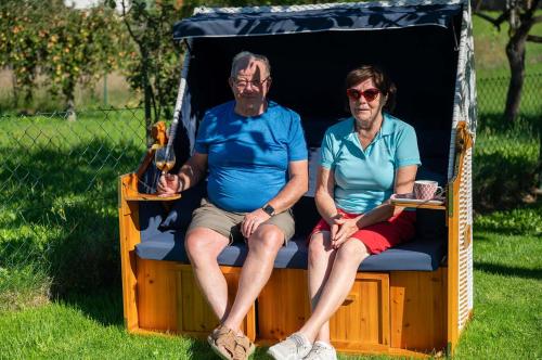 an older man and woman sitting on a play tent at Pension Zur Krone in Martinfeld