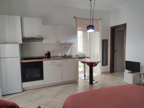 a kitchen with white cabinets and a table in a room at Casa Manilla in Lanciano
