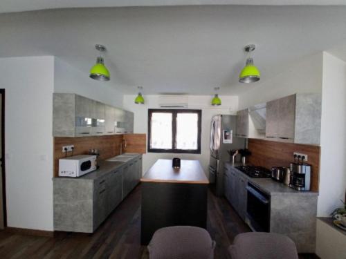 une grande cuisine avec des appareils électroménagers en acier inoxydable et des lumières jaunes dans l'établissement appartement 5 personnes à la montagne, à La Plagne Tarentaise
