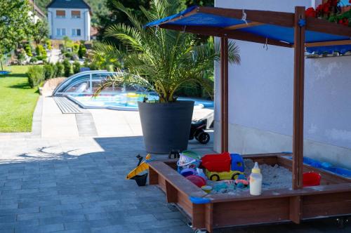 a sandbox with a potted plant and toys in it at Pension Zur Krone in Martinfeld
