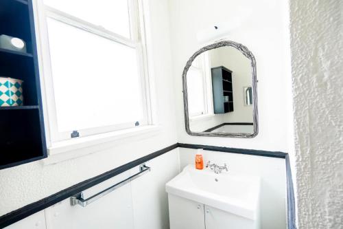 a bathroom with a sink and a mirror at Step Back in Time Charming Victorian with Modern Amenities in Homestead