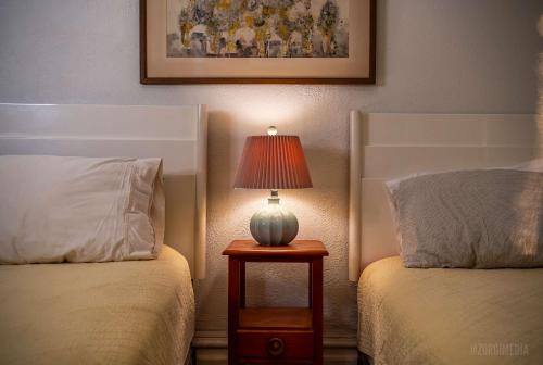 a bedroom with two beds and a lamp on a table at Step Back in Time Charming Victorian with Modern Amenities in Homestead