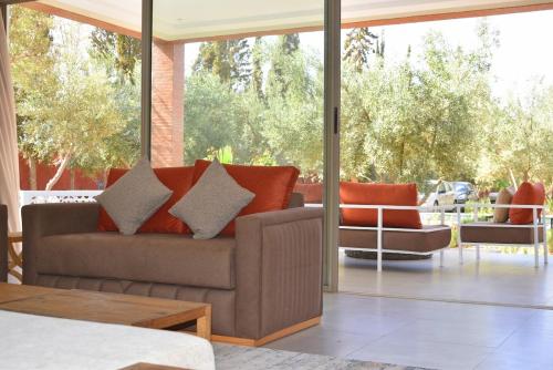 a living room with a couch and a large window at Villa Essalam Marrakech in Marrakech