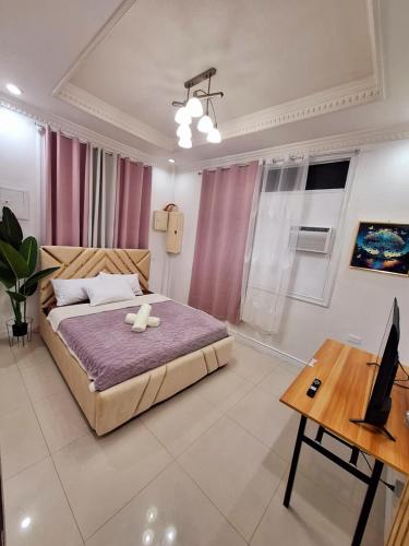 a bedroom with a bed and a desk and a laptop at N3 Studio Room Apartment Transient House Ground Floor near Abreeza Mall, SPMC, SM Lanang, USEP in Davao City