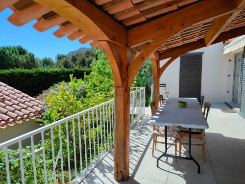une pergola en bois avec une table sur un balcon dans l'établissement L'Escapade des Calanques, à La Ciotat