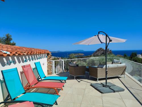 un groupe de chaises et un parasol sur une terrasse dans l'établissement L'Escapade des Calanques, à La Ciotat