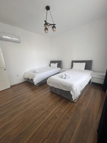 two beds in a room with wood floors at Caesar Resort & SPA - Apartment with 2 Bedroom - Aurelius in Saint Yeorgios