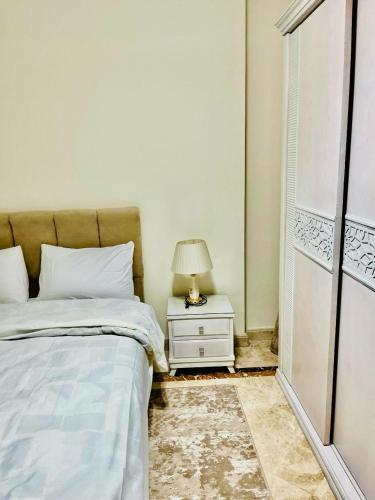 a bedroom with a bed and a lamp on a nightstand at ALEX HOMES - Gleem Luxury Apartments with Direct Sea View in Alexandria