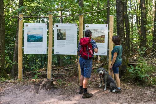 two people and a dog standing next to signs at Ferienwohnung "Dorfblick" in Leinsweiler