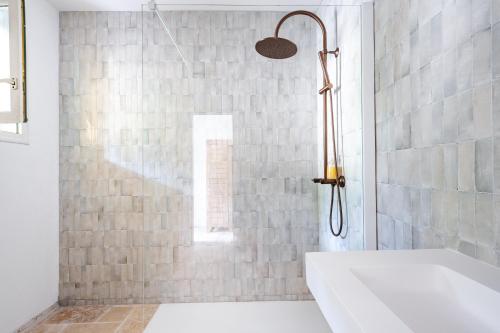 a bathroom with a shower with a white tub at Mas du Loriot in Murs