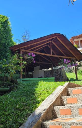 a garden with a wooden pavilion in the grass at Cabaña en Copacabana Antioquia, cerca a Medellín in Copacabana