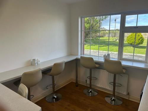 a room with a counter with chairs and a table at Slaney House Bed and Breakfast in Lahinch
