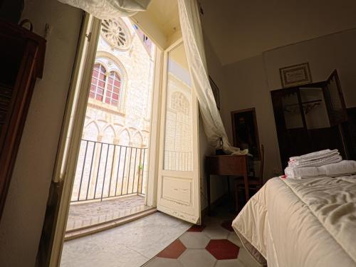 a bedroom with a bed and a large window at Palazzo Framarino dei Malatesta - Noble Floor - XIV Century in Giovinazzo