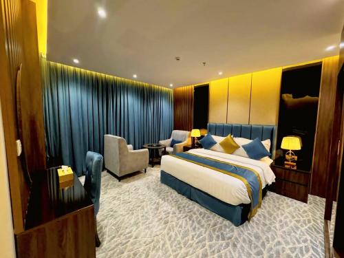 a hotel room with a large bed and a chair at بروليت للشقق الفندقية in Khamis Mushayt
