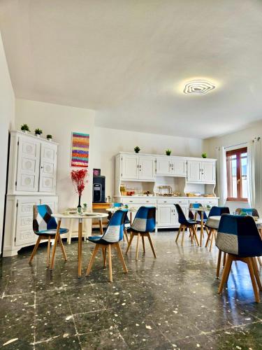 cocina con sillas y mesa en una habitación en I Nidi di Dommos - Camere nel centro storico di Orosei, en Orosei