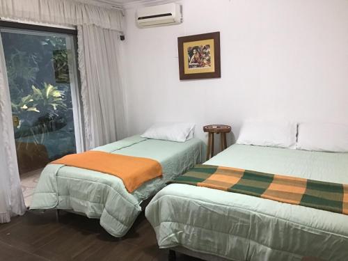 two beds in a room with a window at Granados in Asuncion