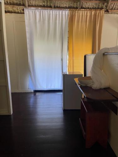 a living room with a white curtain and a table at Playa Paraiso en Magante in La Yagua