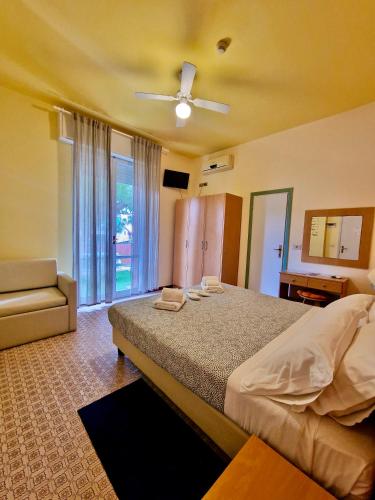 a bedroom with a large bed and a couch at Hotel Rossella in Rimini