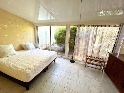 une chambre avec un lit et une grande fenêtre dans l'établissement Maison T2 4 couchages CAP D'AGDE NATURISME CN050-143, au Cap d'Agde