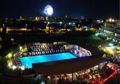 - une vue sur la piscine la nuit avec des feux d'artifice dans l'établissement Maison T2 4 couchages CAP D'AGDE NATURISME CN050-143, au Cap d'Agde