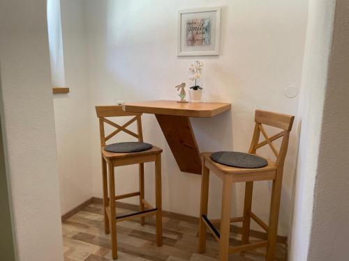 a small table and two stools in a room at Haus Füsslmühle in Fuschl am See