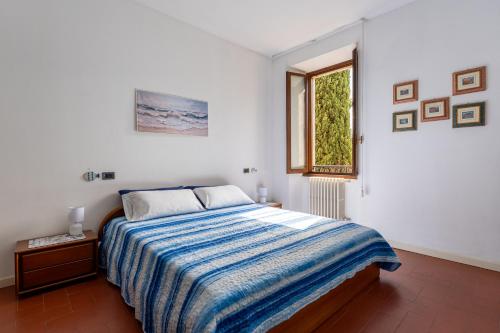 une chambre blanche avec un lit et une fenêtre dans l'établissement Casa Preziosa - Salò, à Salò