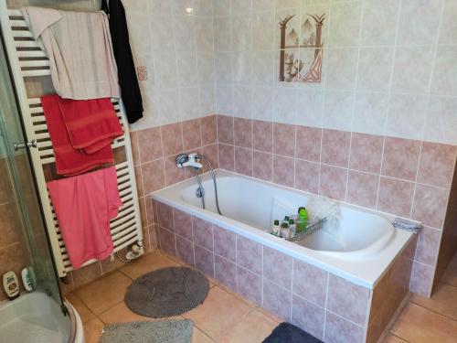 La salle de bains est pourvue d'une baignoire avec du carrelage rose. dans l'établissement Maison 120m2 terrain de 700m2 clôturé, à Mirabeau