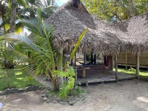 a hut with a bench and a grass roof at Playa Paraiso en Magante in La Yagua