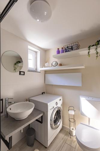 a bathroom with a washing machine and a sink at LaraBella Salt fields view studio in Portorož
